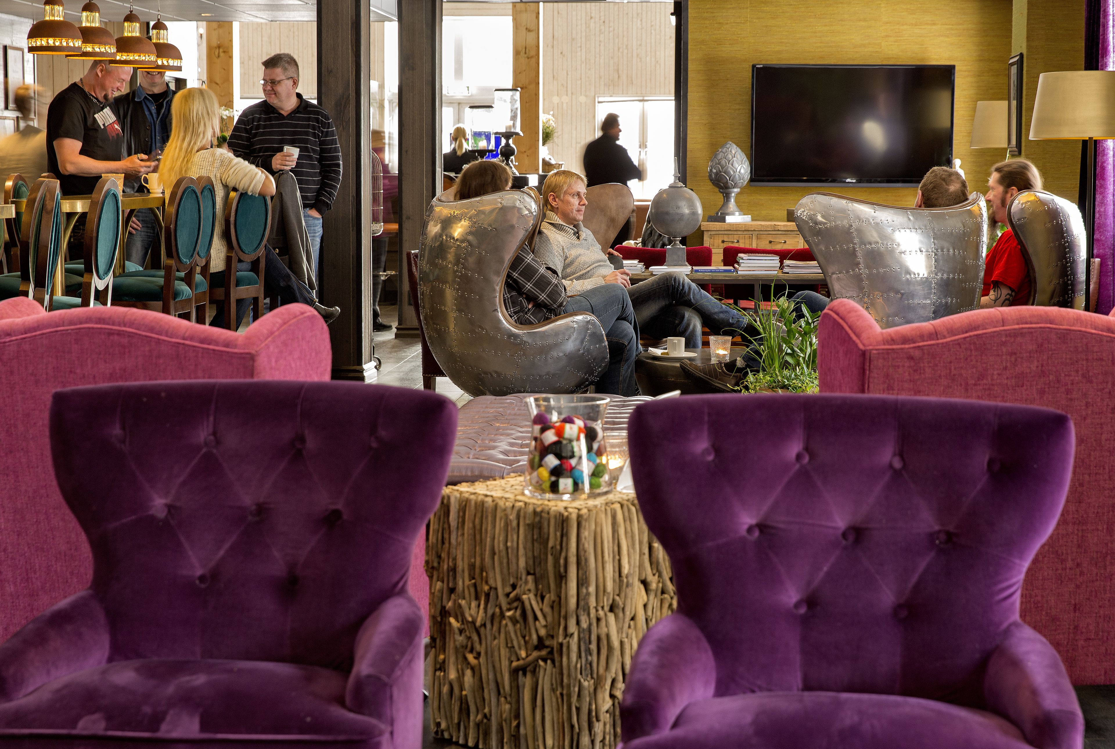 A modern lounge area with comfortable seating, a large flat-screen TV, and a casual dining setup.