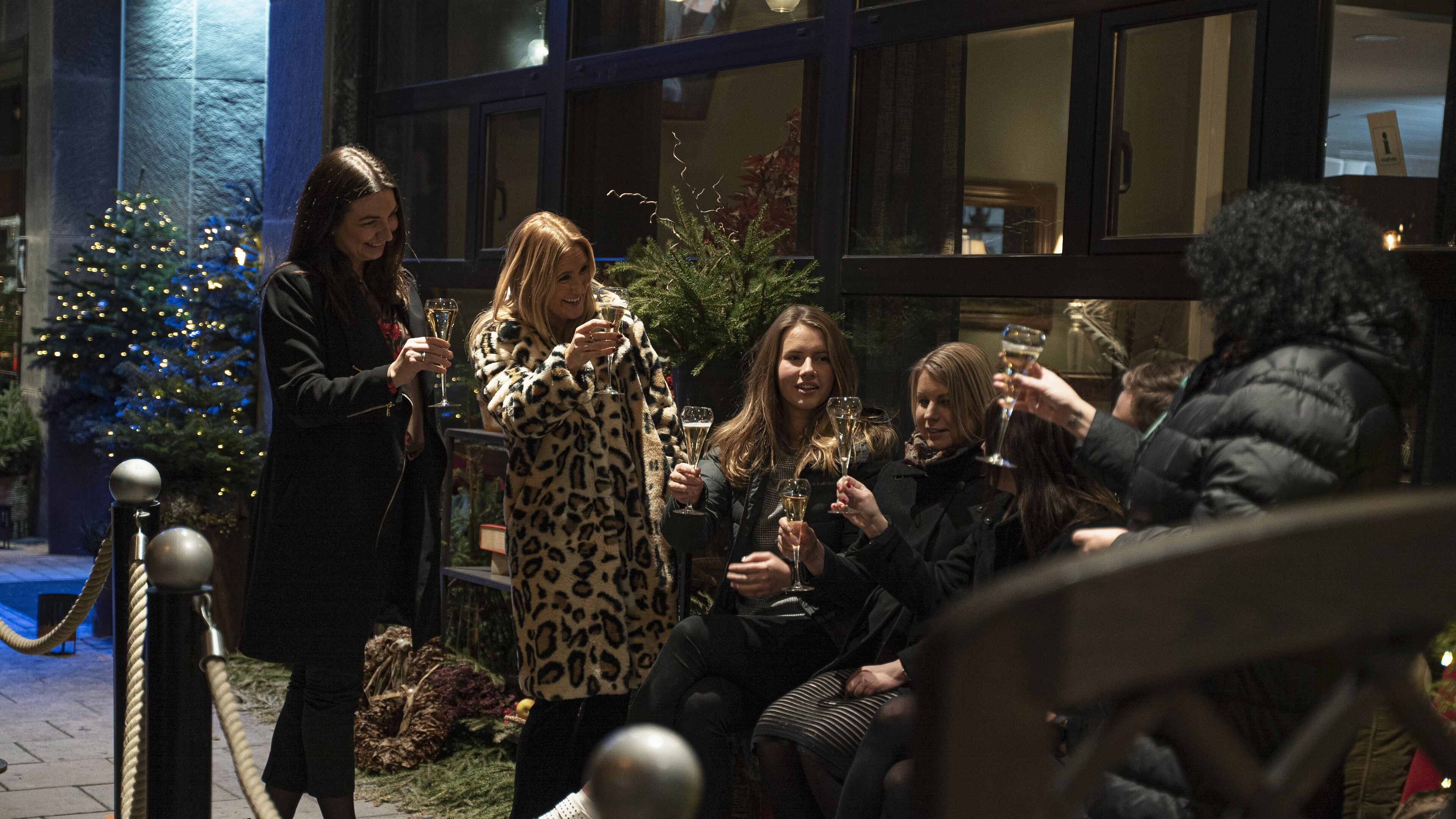A group of people gathered outdoors, holding glasses, possibly celebrating.
