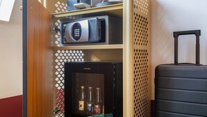 Een minibars met een koelkast, een magnetron en een assortiment drankjes.