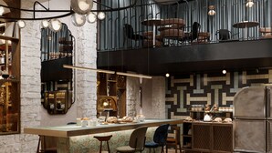 Een moderne keuken met een centraal eiland, barstoelen en hanglampen.
