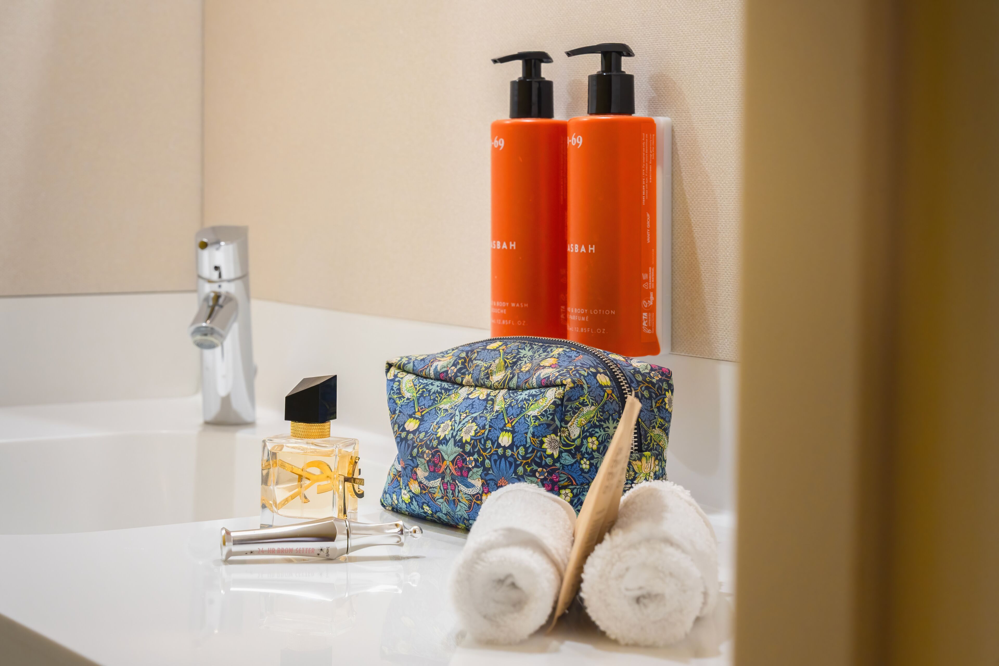 A bathroom counter with toiletries, a faucet, and towels.