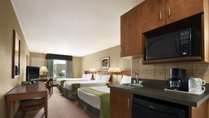 Habitación de hotel con dos camas, un escritorio, un televisor, un microondas, una cafetera y un lavamanos.