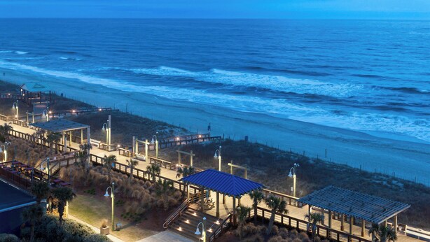 A coastal hotel with a boardwalk, beach access, and a gazebo.