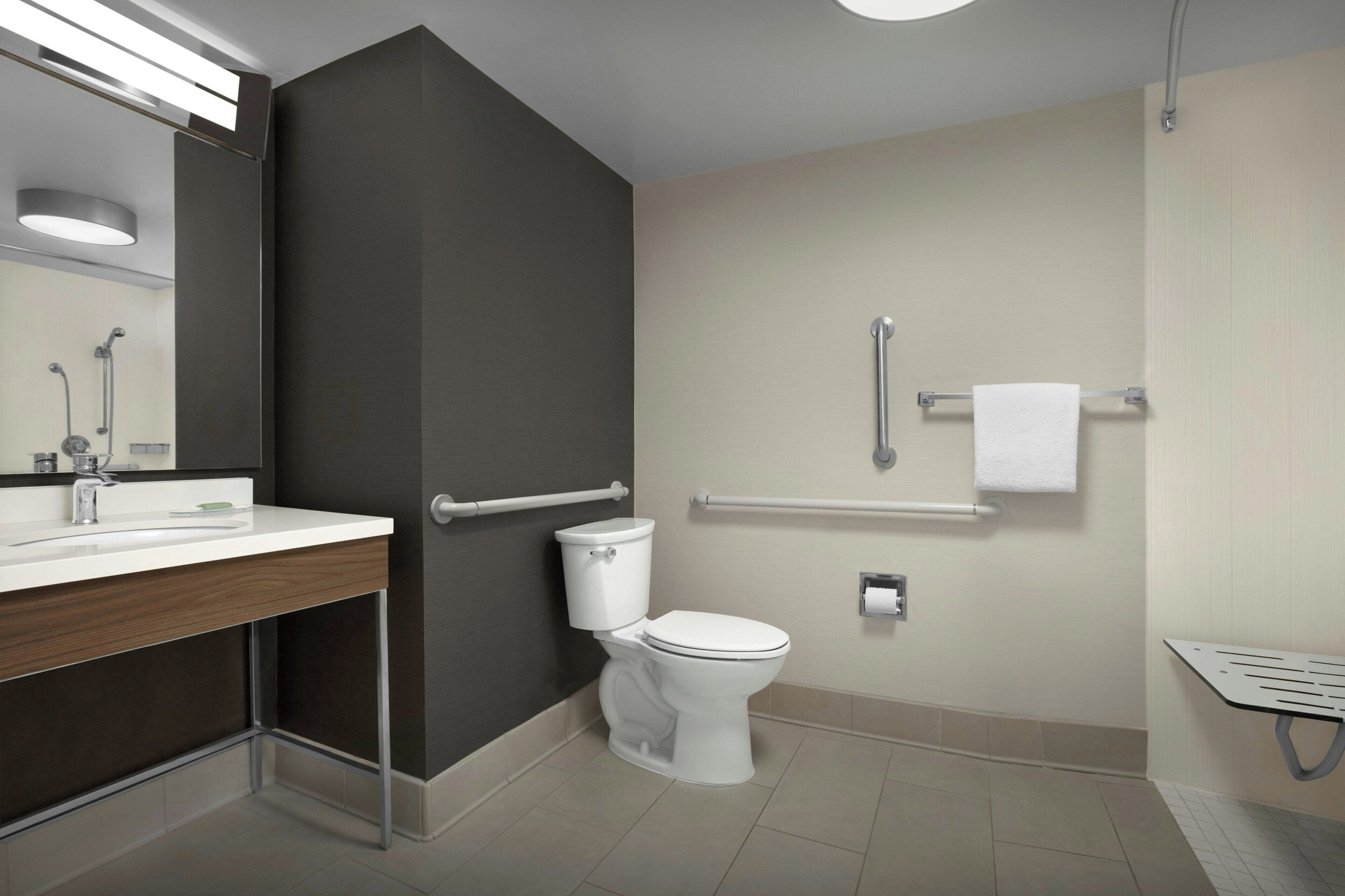 A modern bathroom with a toilet, sink, and shower.