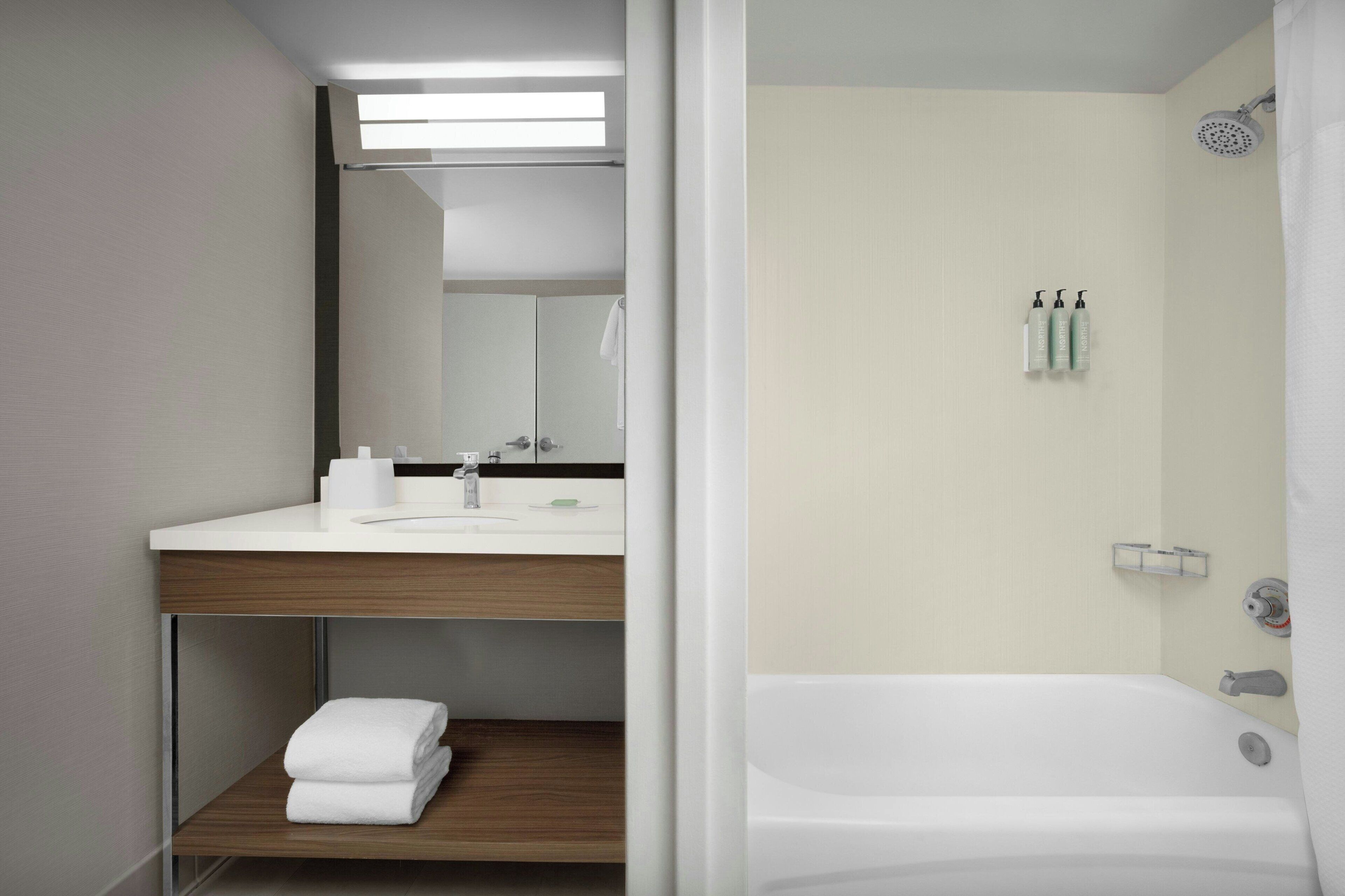 Une salle de bain moderne avec un lavabo, un miroir et une douche.
