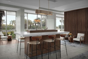 A modern kitchen with a large island, bar stools, and a hanging light fixture. - Courtyard Carolina Beach Oceanfront (Carolina Beach)