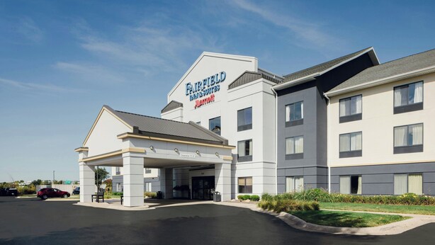 Un hôtel Fairfield Inn & Suites doté d’une entrée abritée, d’un parking et offrant une vue sur un ciel dégagé.