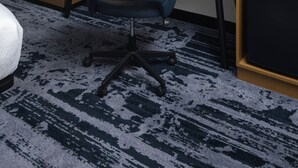 Une chambre d’hôtel équipée d’un bureau, d’une chaise, d’un grand miroir, d’un téléviseur à écran plat et d’un four à micro-ondes.