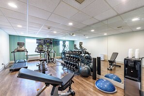 A gym with exercise equipment, a treadmill, a rowing machine, and a water dispenser. - Holiday Inn Express Hotel & Suites Bastrop by IHG (Bastrop)