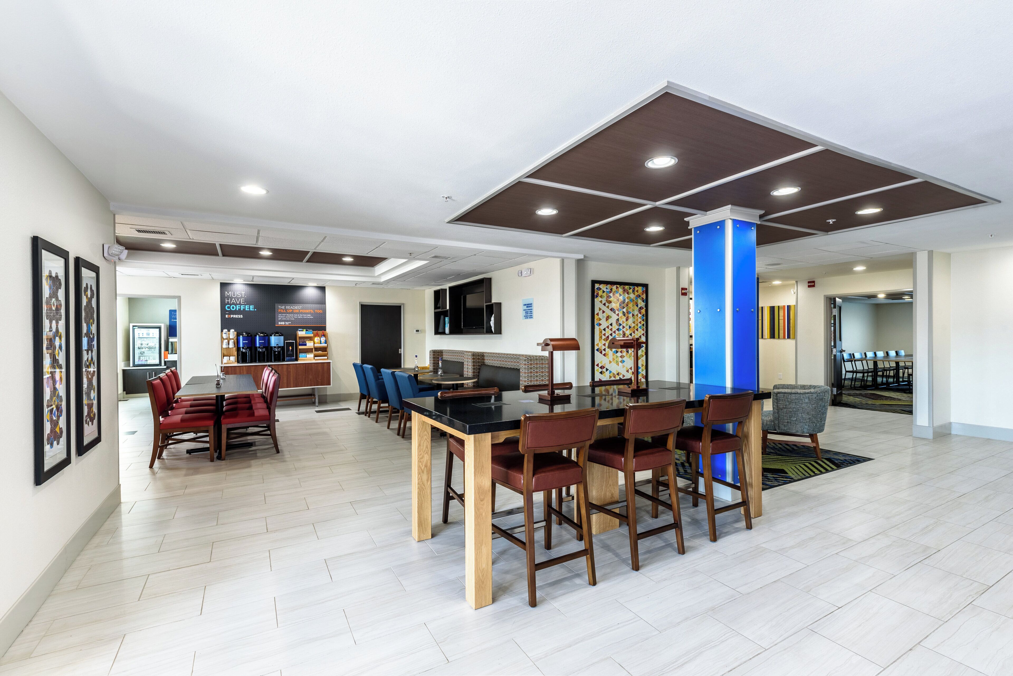A spacious dining area with a long table and multiple chairs, a bar area with seating, and a coffee station.