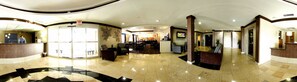A hotel lobby with a reception desk, seating area, and a television screen. - Holiday Inn Express Hotel & Suites Bastrop by IHG (Bastrop)