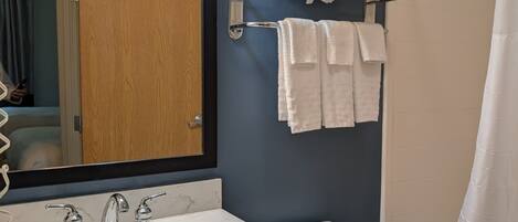 A bathroom with a sink, mirror, towel rack, and toilet.