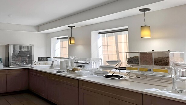 A modern kitchen with a central island, pendant lighting, and a view of the city through large windows.