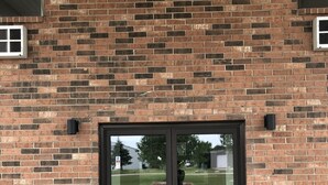 A brick building with a glass door and a small window.