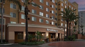 A multi-story hotel with a brown facade, palm trees, and a sign that reads "Residence Inn by Marriott." - Residence Inn By Marriott Anaheim Resort Area (Garden Grove)