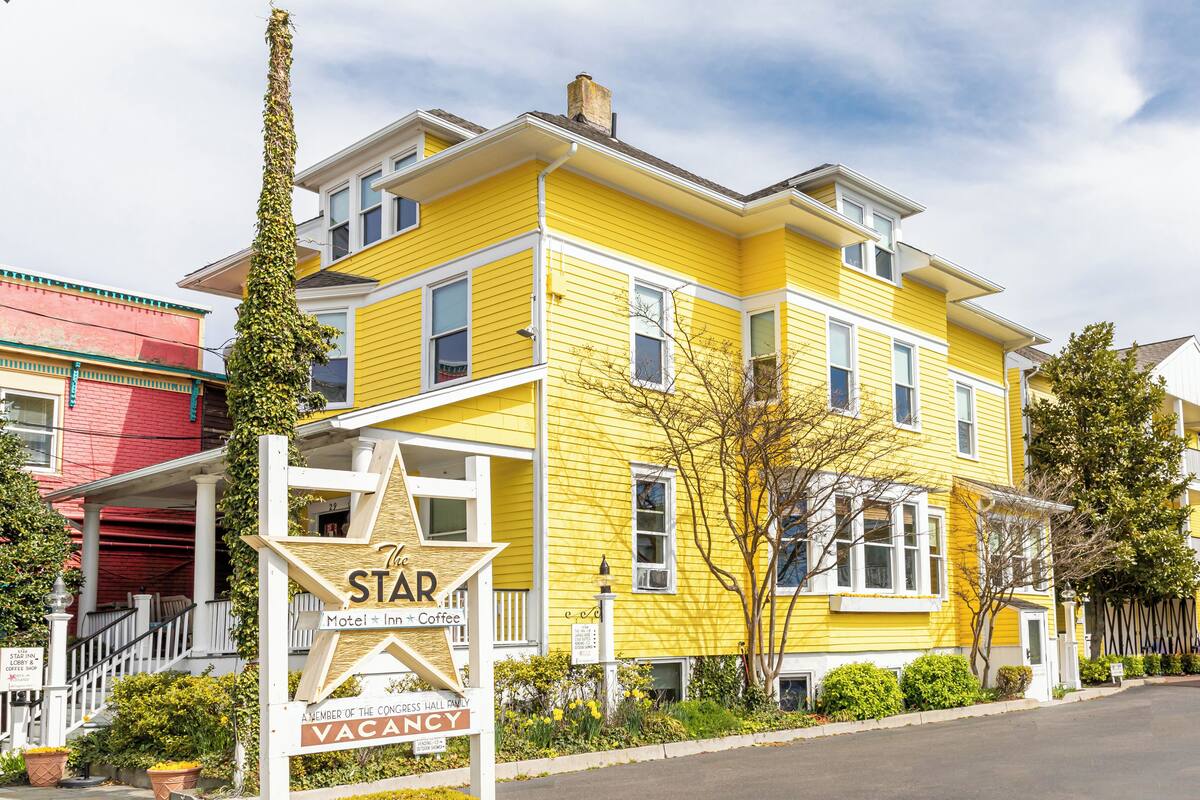 A yellow building with a sign indicating it's a motel, inn, and coffee shop.
