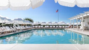 A swimming pool with white umbrellas and lounge chairs. - The Star Inn (Cape May)