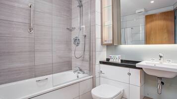 A modern bathroom with a bathtub, shower, toilet, and sink.