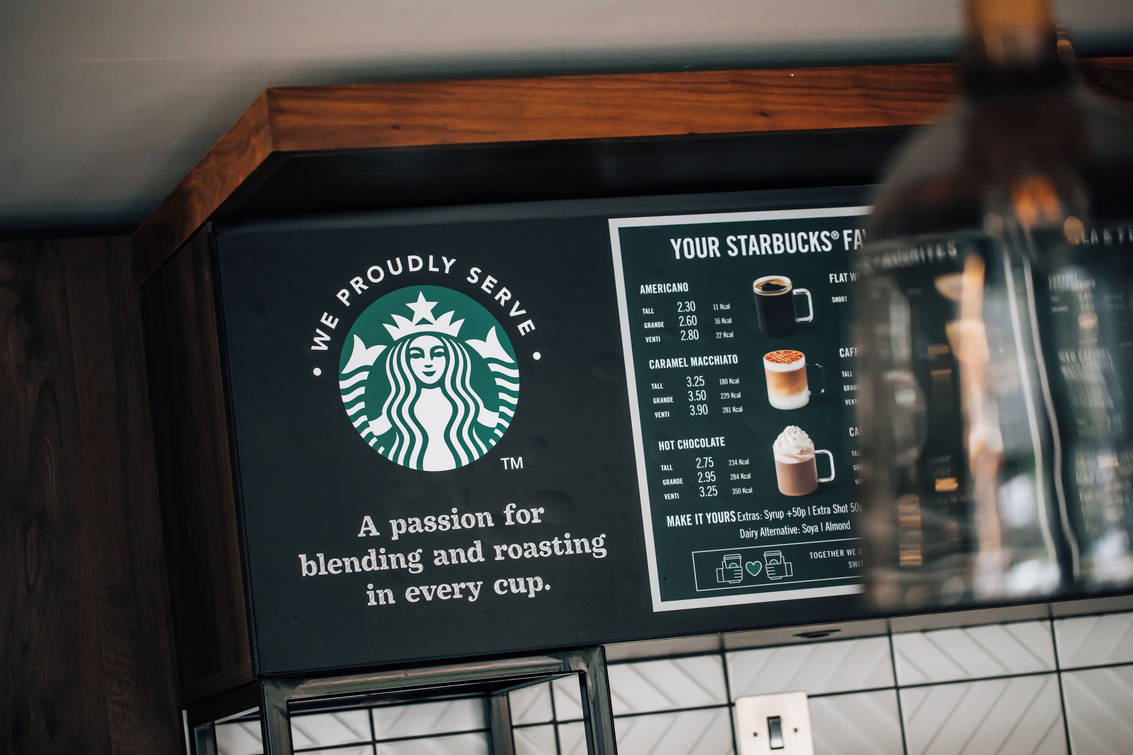 A Starbucks menu board with drink options and prices.