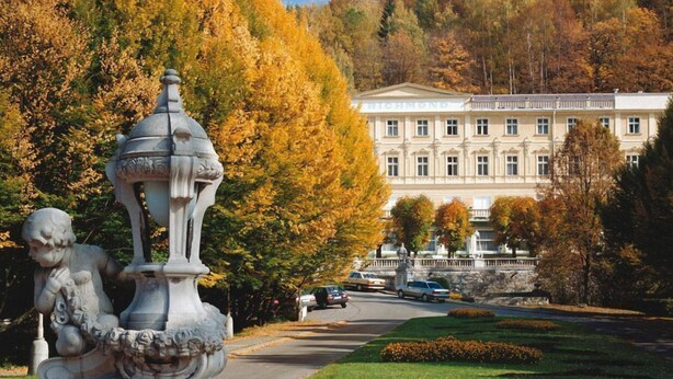A classical building with a symmetrical facade, a statue in the foreground, and a well-maintained lawn. - Parkhotel Richmond (Karlovy Vary)