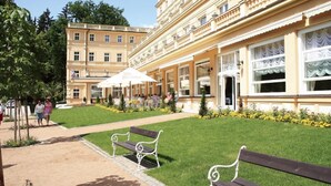 A building with a central courtyard, benches, and a covered seating area. - Parkhotel Richmond (Karlovy Vary)
