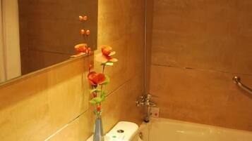 A bathroom with a white sink, mirror, and a shower.