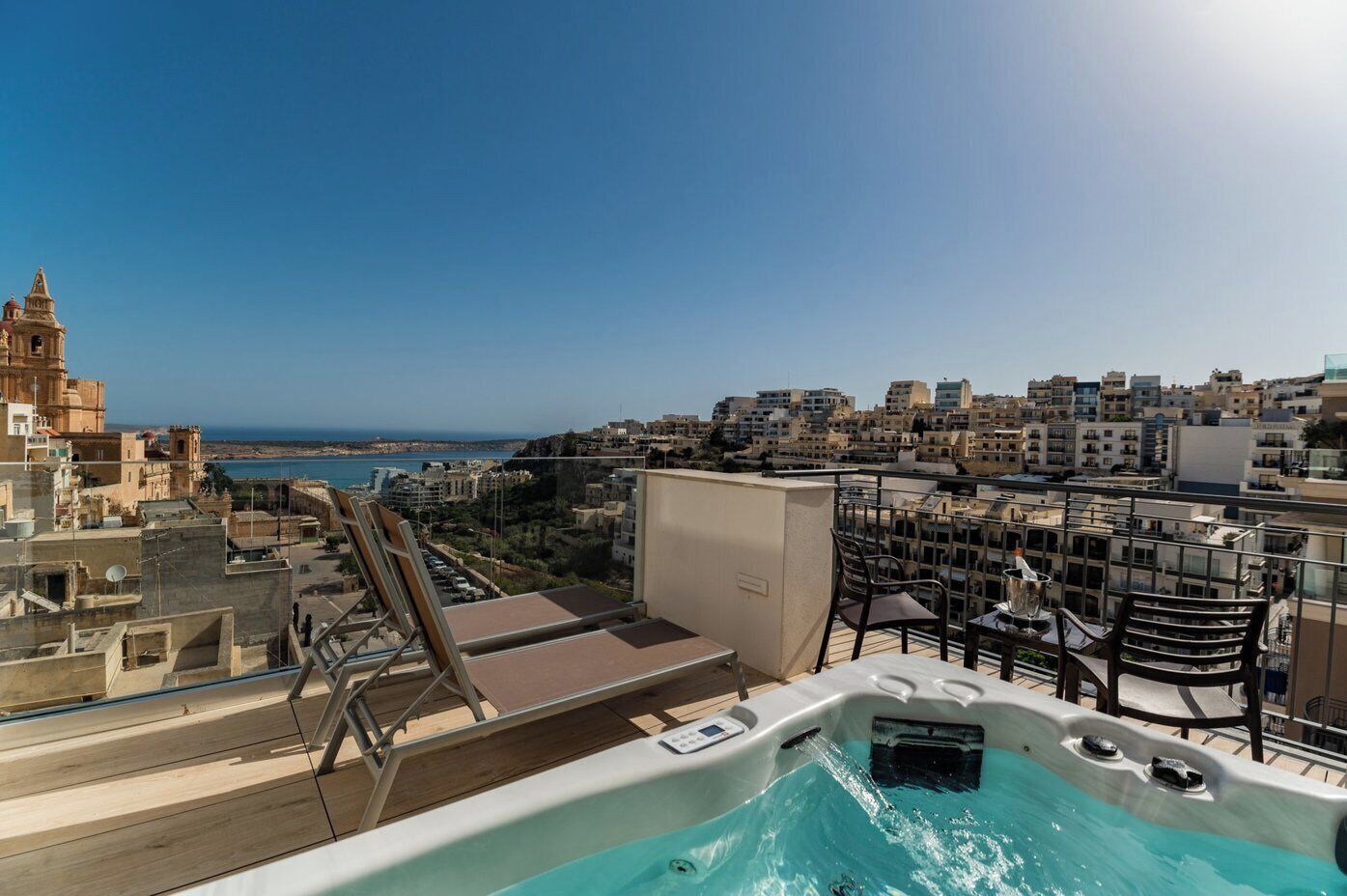 Un área de piscina en la azotea con vistas a la ciudad y al mar.