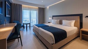 A modern hotel room with a large bed, a desk, and a chair.