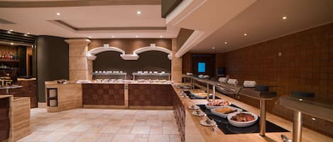 A buffet area with multiple serving stations, a bar area, and a tiled floor.