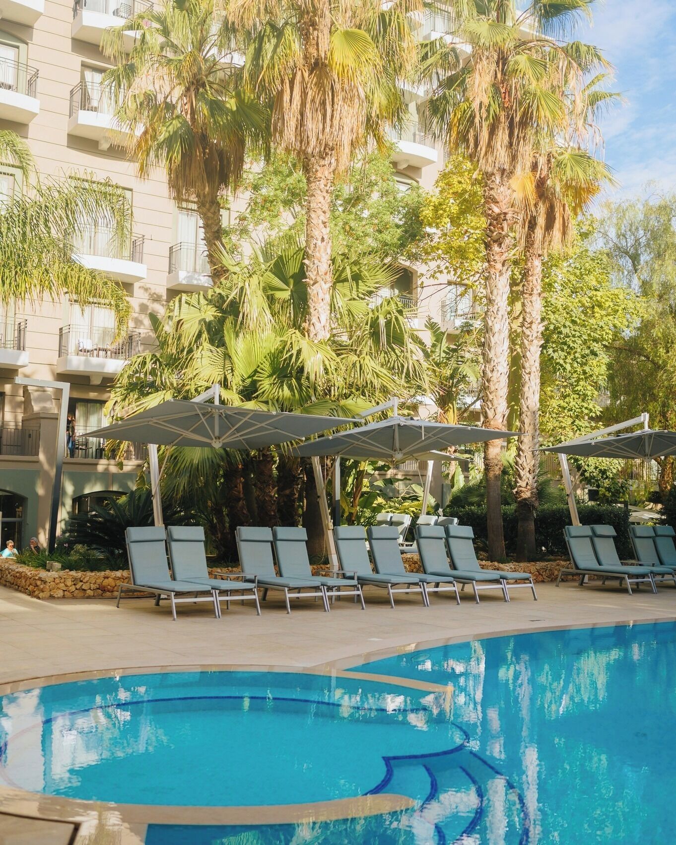 Een binnenzwembad, 2 buitenzwembaden en parasols bij het zwembad