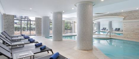 A poolside area with lounge chairs and a swimming pool.