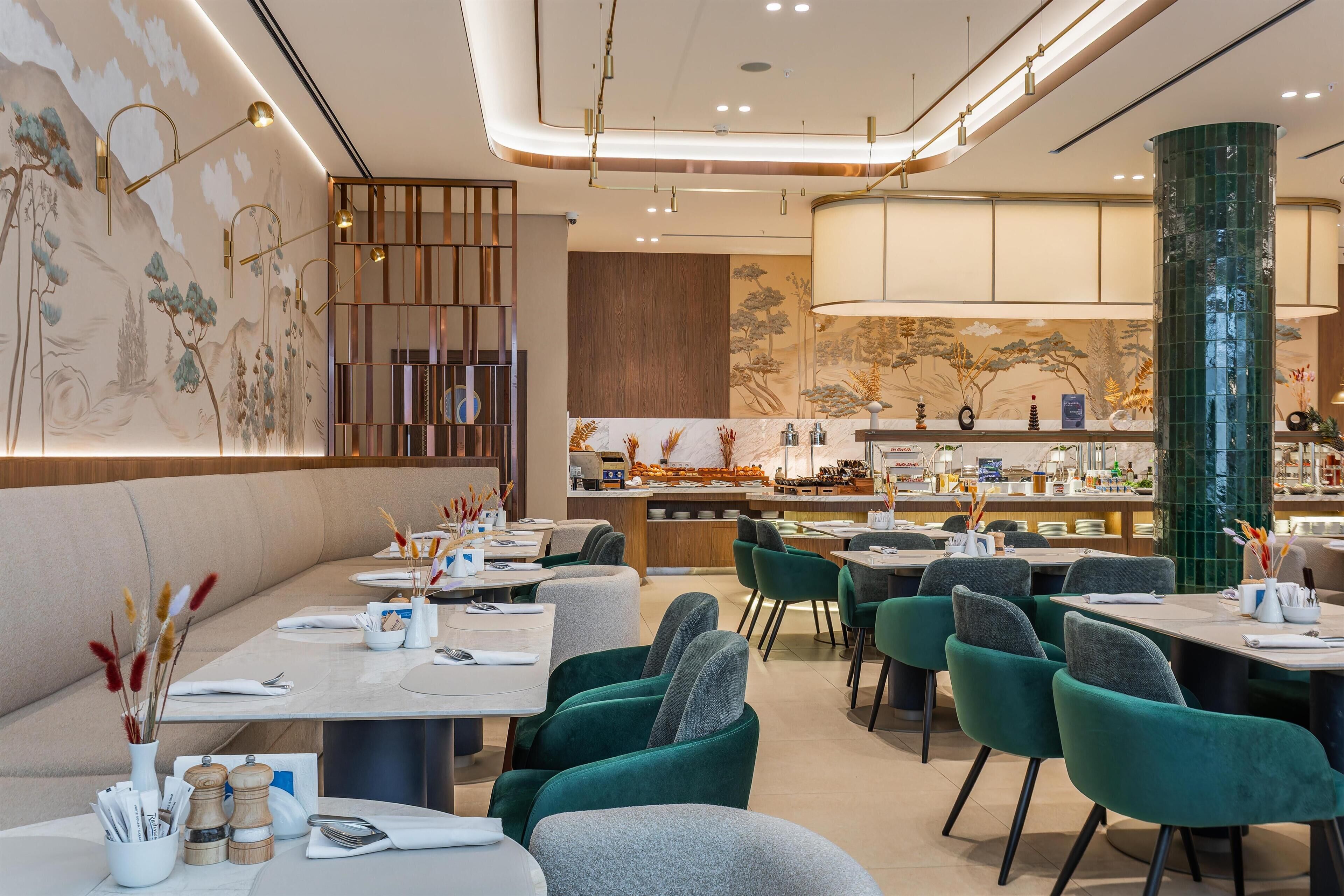 A restaurant with a modern interior, featuring a bar area, seating arrangements, and decorative wall art.