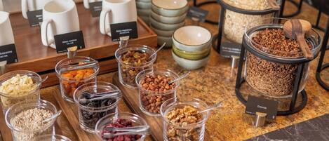 A buffet with various food items including granola, nuts, and dried fruits.