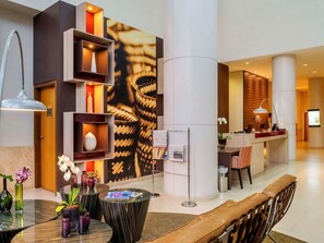 A modern lobby with a reception desk, seating area, and decorative elements. - Mercure Guarulhos Aeroporto Hotel (Guarulhos)