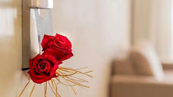 A door with a silver handle and a bouquet of red roses placed on it.