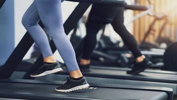 Una persona corriendo en una caminadora en un gimnasio.