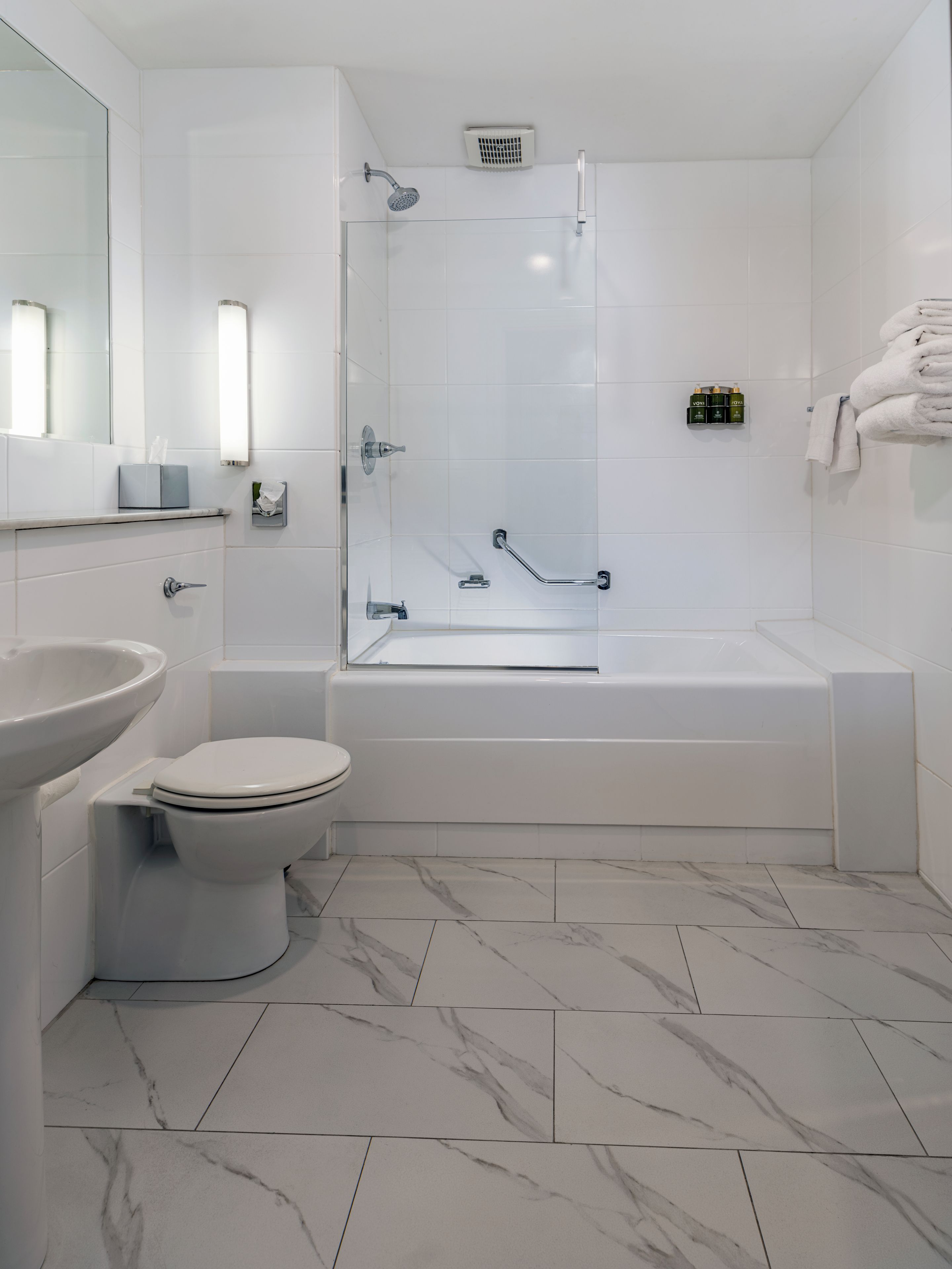 A modern bathroom with a toilet, sink, shower, and bathtub.