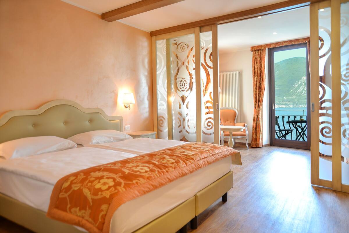 Habitación de hotel con una cama grande, una silla, una mesa y vistas al exterior.