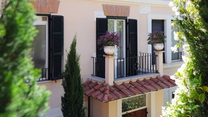 A two-story building with multiple windows, a balcony with potted plants, and a tiled roof. - Best Western Ars Hotel (Rome)