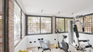 A gym with exercise equipment, a bench, and a basket of apples. - Best Western Ars Hotel (Rome)