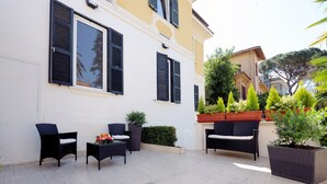 An outdoor seating area with wicker furniture and potted plants. - Best Western Ars Hotel (Rome)
