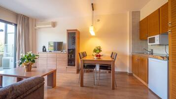 Una cocina moderna con armarios de madera, una mesa de comedor con sillas y un horno empotrado.