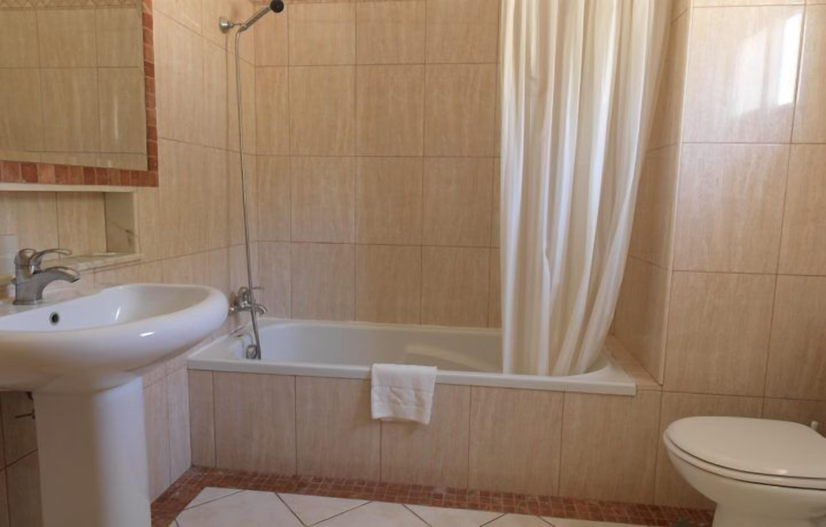 A bathroom with a sink, bathtub, and toilet.