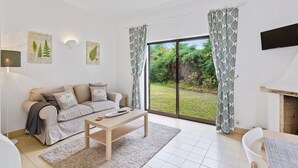 A modern living room with a sofa, coffee table, and a fireplace. - Prado do Golf (Loulé)