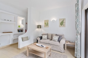 A modern living room with a sofa, a coffee table, and built-in shelves. - Prado do Golf (Loulé)