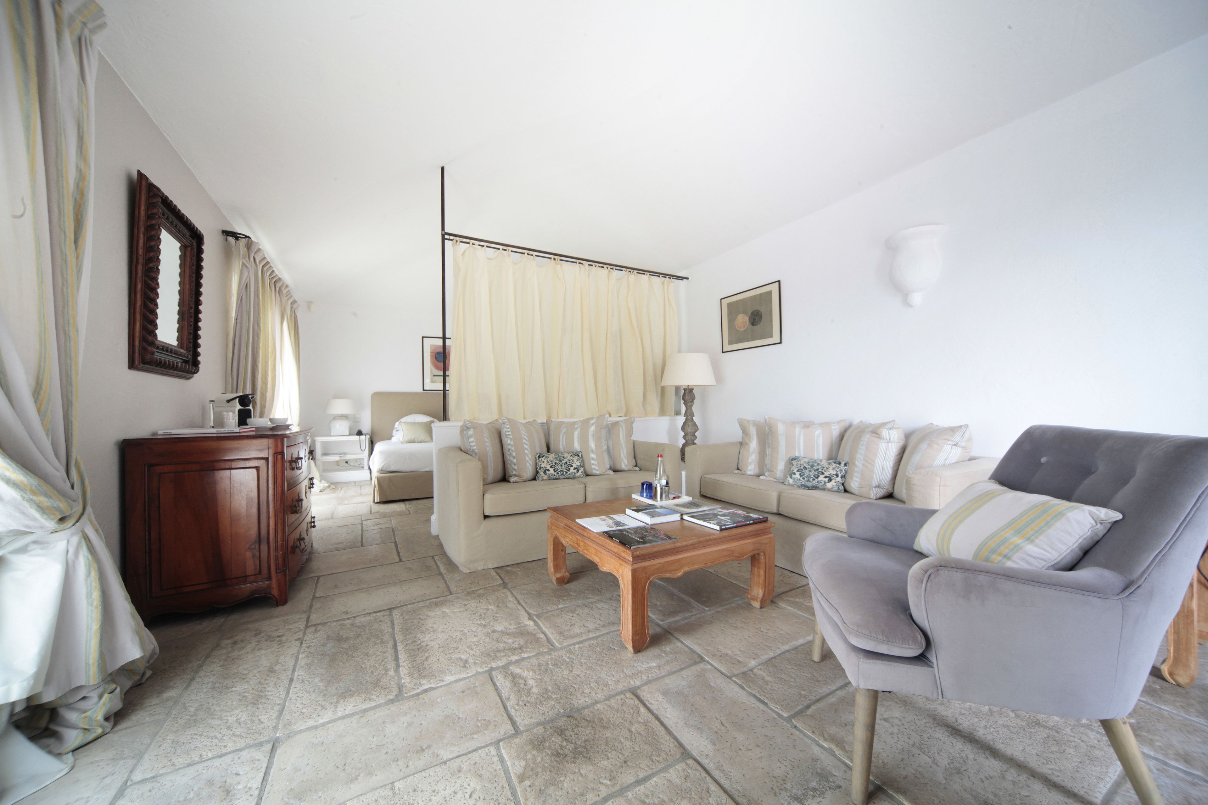 A living room with a sofa set, a coffee table, a cabinet, and a lamp.