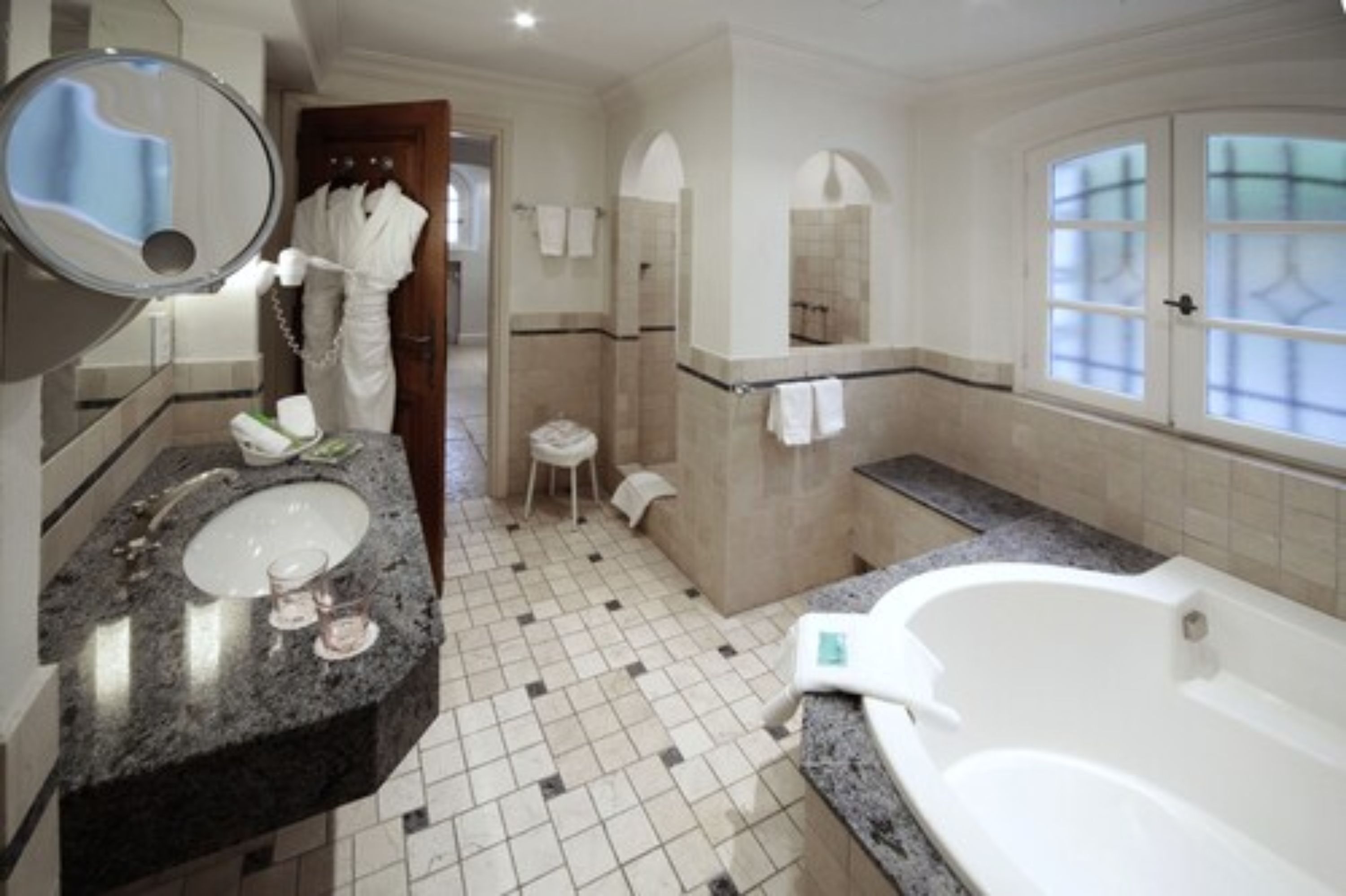 A modern bathroom with a large sink, a bathtub, and a shower area.