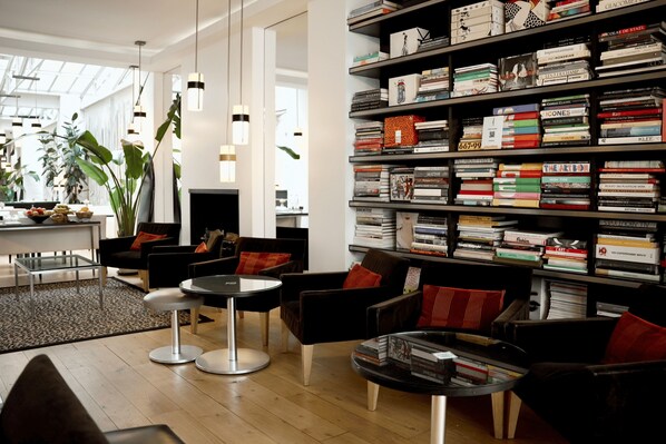 Une bibliothèque moderne dotée d’étagères, de sièges confortables et d’une grande fenêtre.
