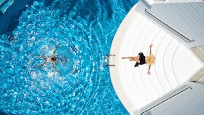 A swimming pool with a person swimming and another person relaxing on the poolside. - Lagos de Fañabé (Adeje)