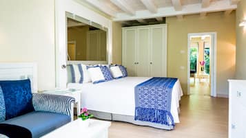 Une chambre à coucher comprenant un lit, une table de chevet, une chaise et donnant sur un jardin grâce à une porte ouverte.